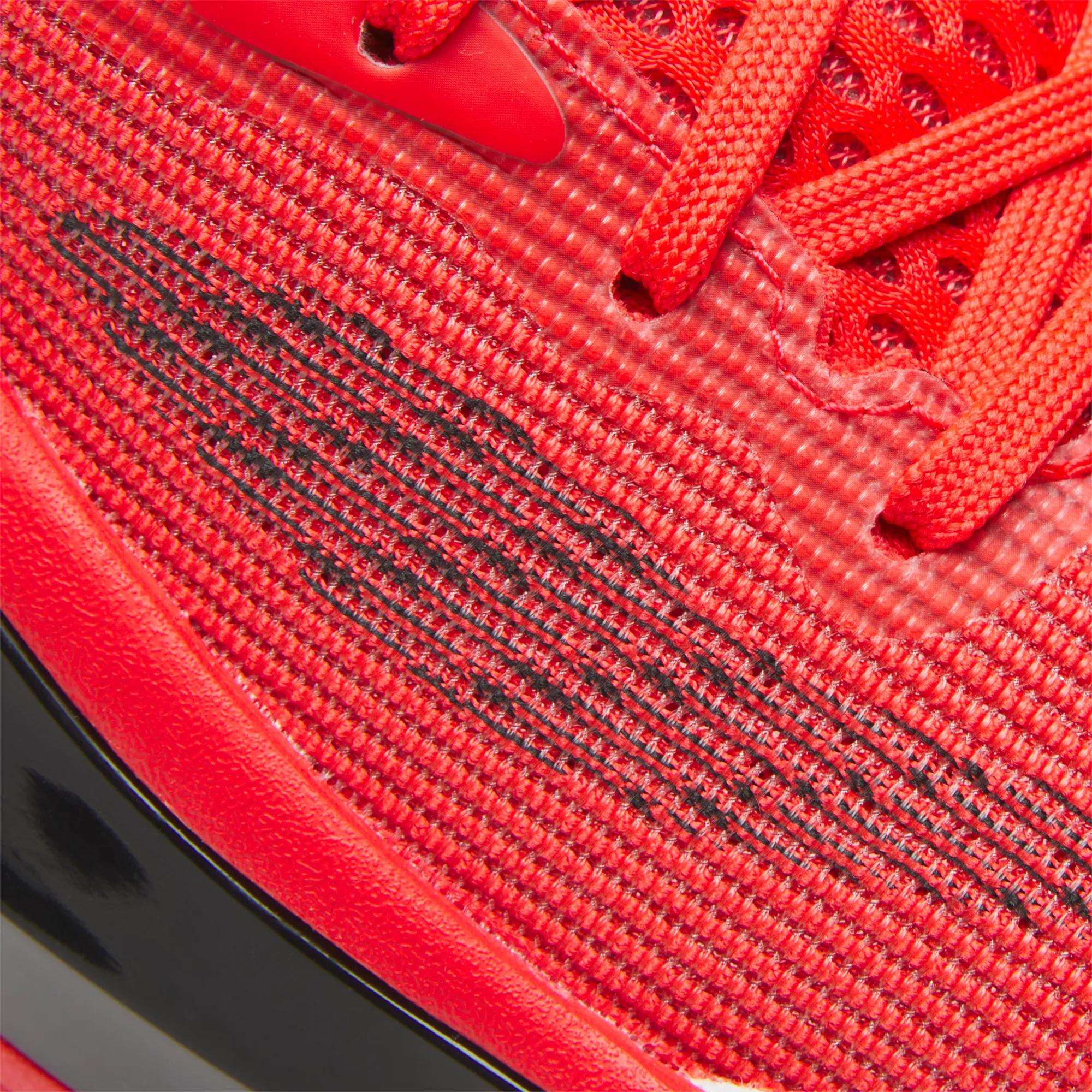 Close-up of Reebok Engine A 26 Basketball Shoes featuring bright red textured mesh fabric, matching red laces, a black streaked side design, and part of a black midsole for enhanced stability.