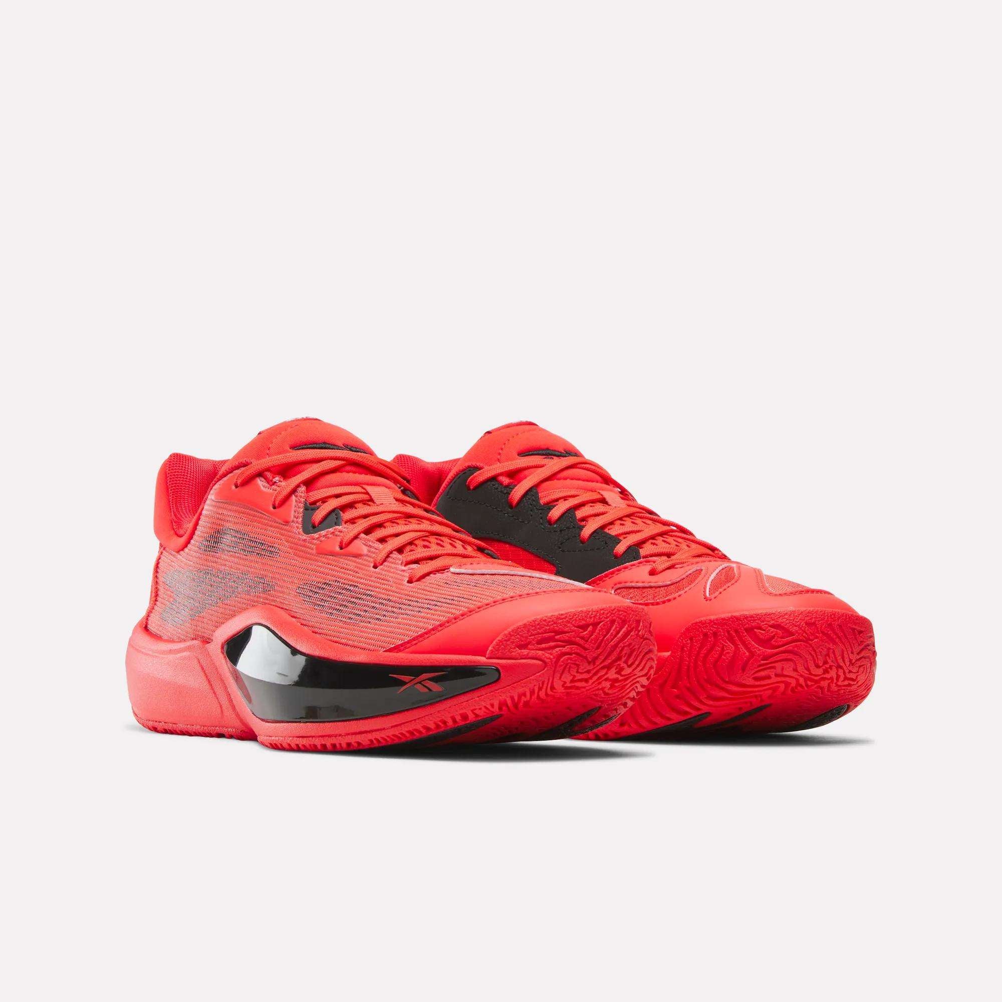 The Reebok Engine A 26 Basketball Shoes, featuring a bright red design with black accents and textured soles for energy return and stability, are positioned side by side on a white background.