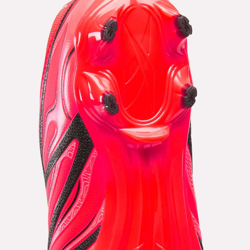Bright pink Reebok Sidewinder 26 Pro Firm Ground Cleats showing the sole plate with black studs for firm ground ball control.