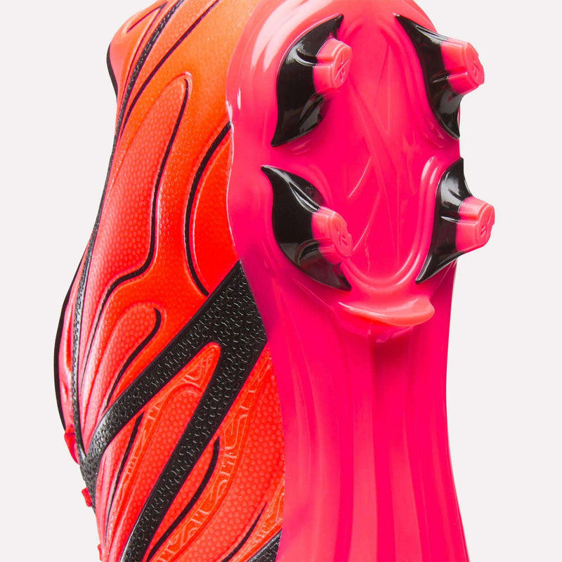 Close-up of the heel and sole of the Reebok Sidewinder 26 League Firm Ground Cleats in bright red and pink with black accents, featuring three black firm ground studs on the sole, shown against a white background.
