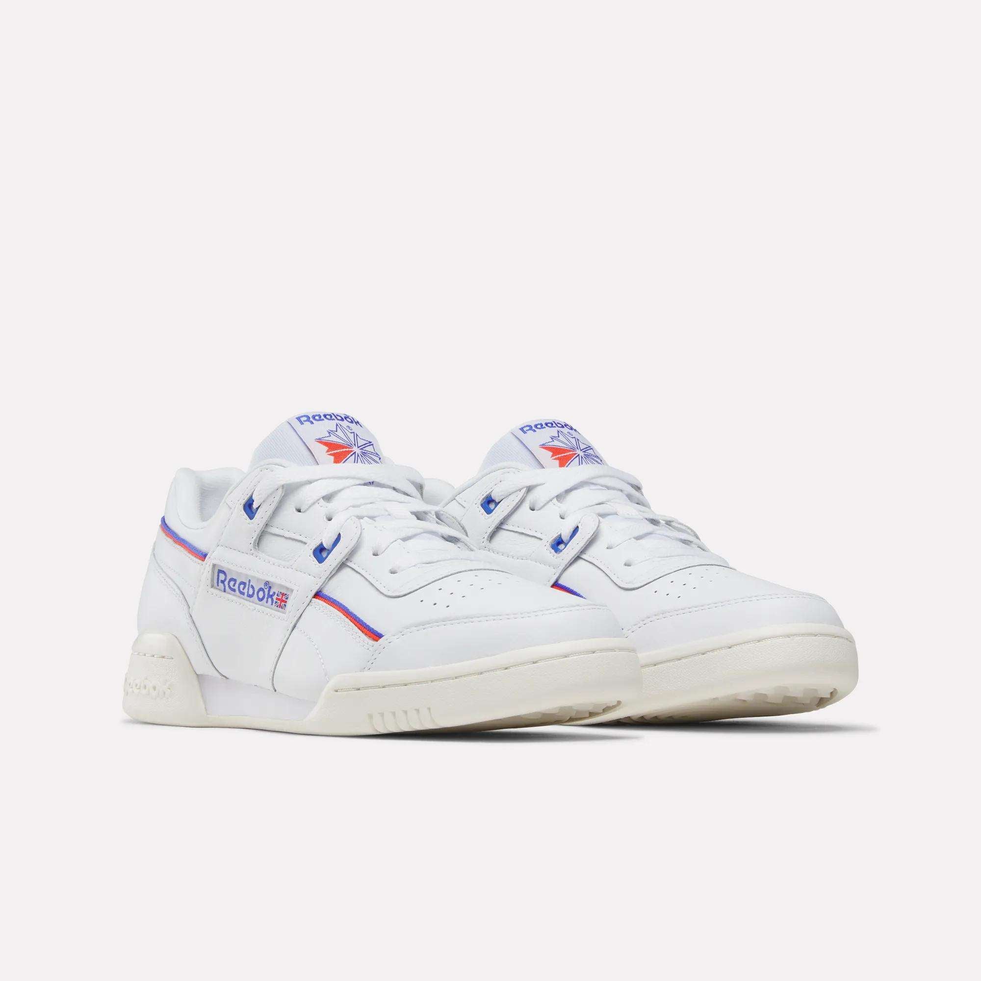 A pair of Reebok Women's Club C 85 Shoes in white leather with blue and red accents, featuring the Reebok logo on the sides and tongue, displayed against a plain white background—timeless style for any outfit.