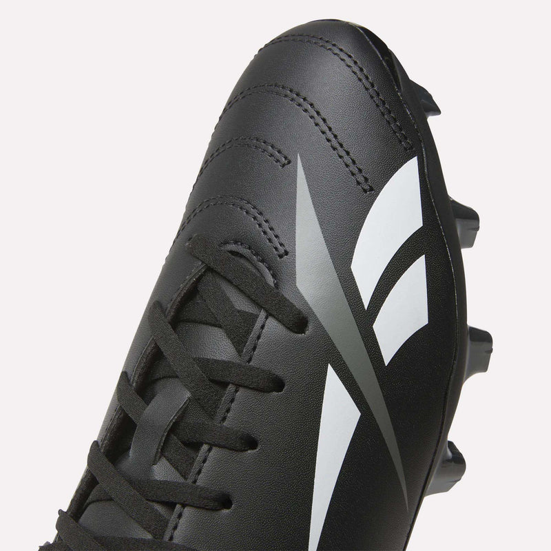 A close-up of the Reebok Strike Multi Ground Soccer Cleats in black, featuring white and gray graphic details, with visible laces and part of the sole displaying turf studs.