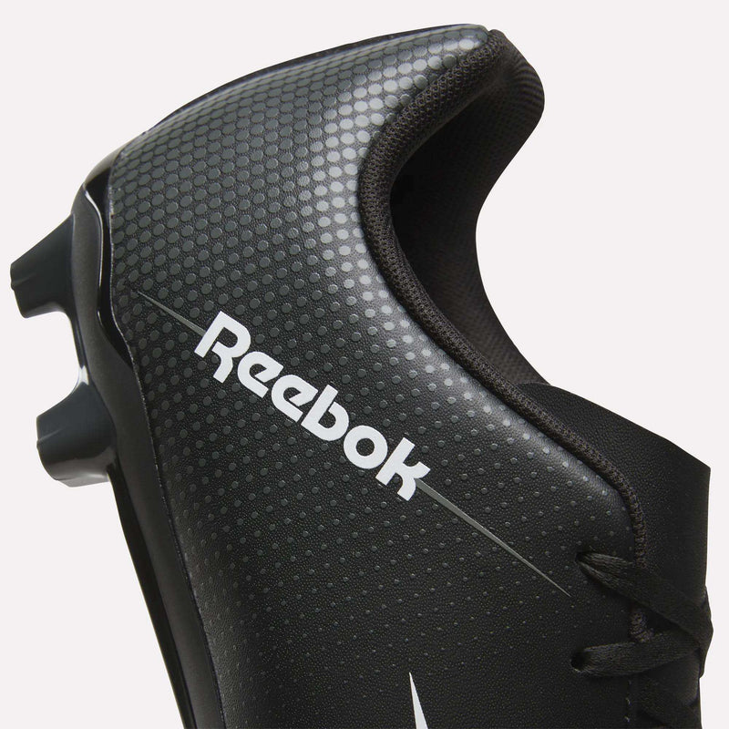 Close-up of a black Reebok Strike Multi Ground Soccer Cleat designed for turf, featuring a dot pattern, white Reebok logo, and part of the cleat studs visible on the left side.