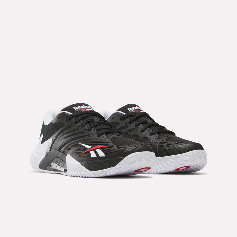 The Reebok Phase EVO Tennis Shoes feature a black finish with white soles, white and red accents, and the Reebok logo on the sides. They offer responsive rebound and are displayed against a plain light background.