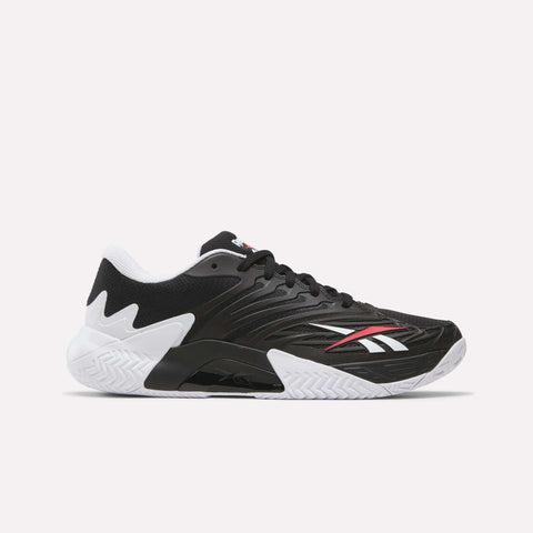 The Reebok Phase EVO Tennis Shoes in black feature white and red accents, a white textured sole, and a low-cut design—perfect for those seeking durable tennis footwear with excellent rebound.