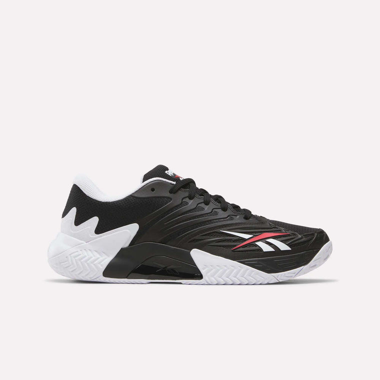 The Reebok Phase EVO Tennis Shoes in black feature white and red accents, a white textured sole, and a low-cut design—perfect for those seeking durable tennis footwear with excellent rebound.