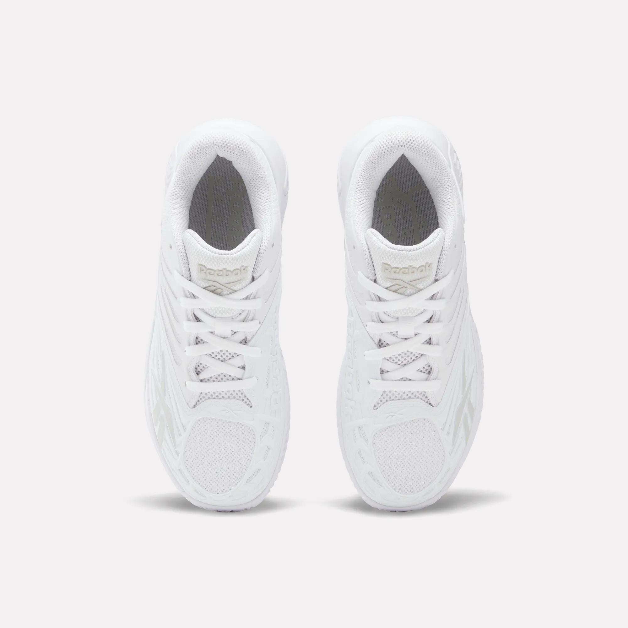 A pair of Women's Phase Evo Tennis Shoes by Reebok, shown in white from above, displaying the laces, mesh accents, and Reebok branding on the tongues.