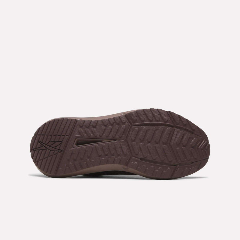 The image shows the sole of a brown Reebok Women's Cityride 2 Running Shoe with a textured tread, angular and curved grooves, FuelFoam cushioning, and the Reebok logo near the heel on a plain white background.