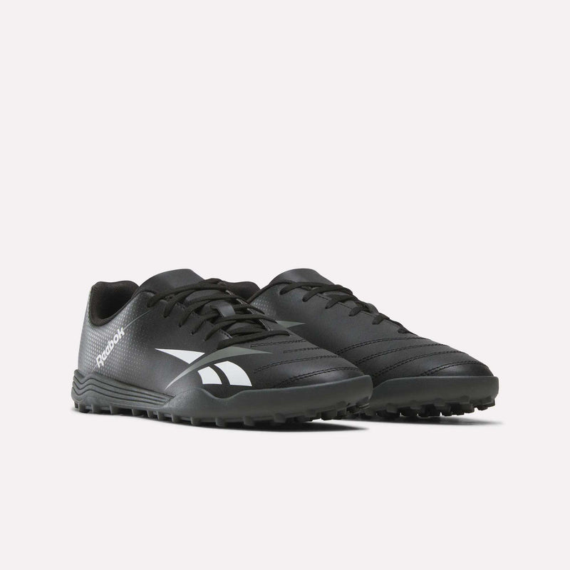 A pair of Reebok Strike Turf Soccer Shoes in black, accented with white logos. Ideal for soccer practice, these shoes showcase textured rubber soles and detailed stitching on the upper, all presented against a plain white background.
