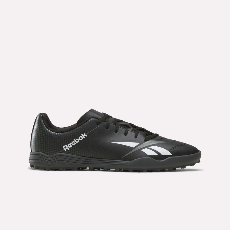 The Reebok Strike Turf Soccer Shoes in Black/White, featuring a white logo and accents, are designed for turf sports and perfect for soccer practice. Shown here is a side profile view on a plain white background.