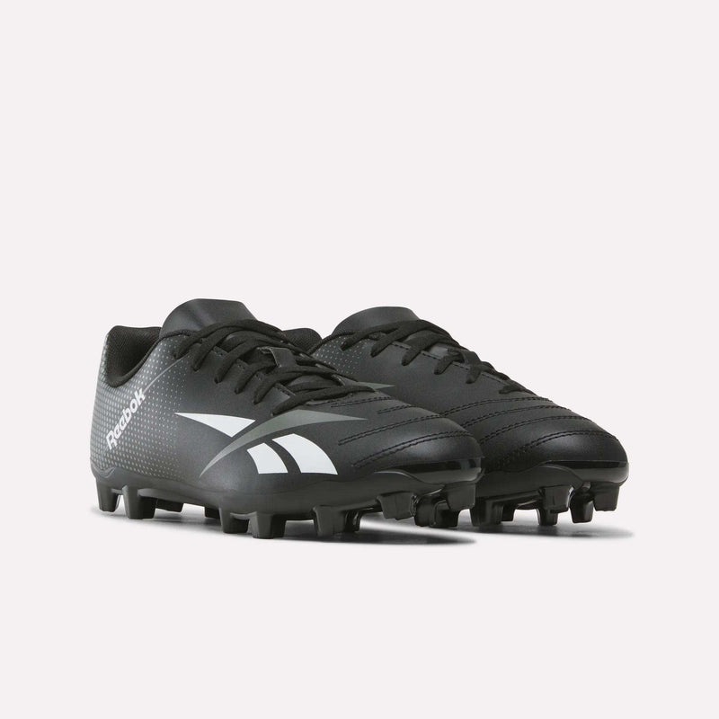 A pair of Reebok Strike Multi-Ground Soccer Shoes for big kids, featuring a black design with white logos, black laces, and molded studs for turf play, displayed on a plain white background.