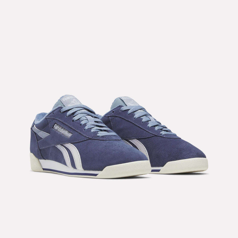Women’s Freestyle Lo shoes by Reebok in blue suede with a low-top silhouette, light blue laces, and white midsoles.
