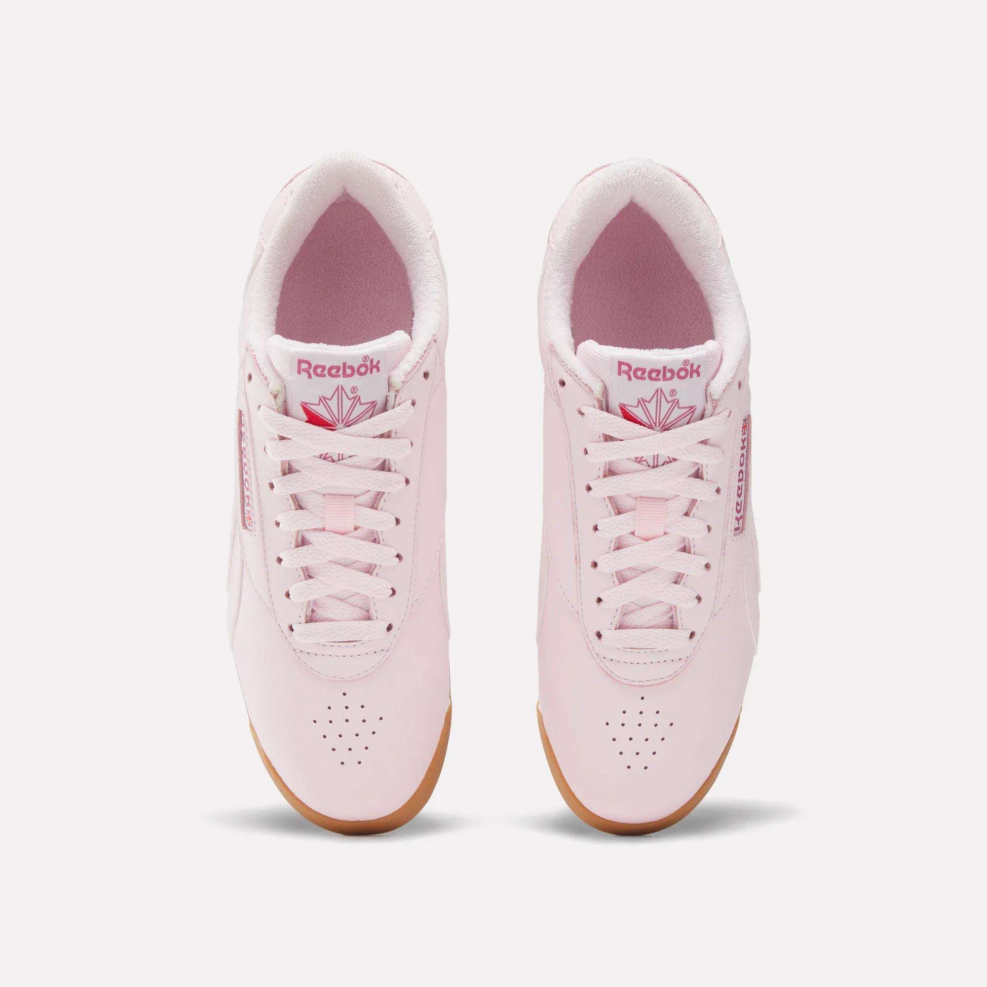 A pair of Women's Freestyle Lo Shoes by Reebok in light pink with white soles and pink laces, seen from above on a white background. Features the Reebok logo in pink on the tongues and sides, ideal for everyday wear.