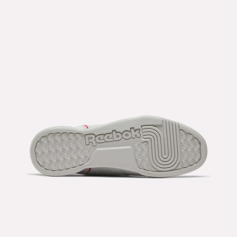 The sole of a white Reebok Workout Plus Shoe is displayed facing upward, prominently showcasing the Reebok logo in bold lettering along with textured tread patterns for grip, emphasizing the classic vintage touches that define these retro-inspired Workout Plus Shoes.