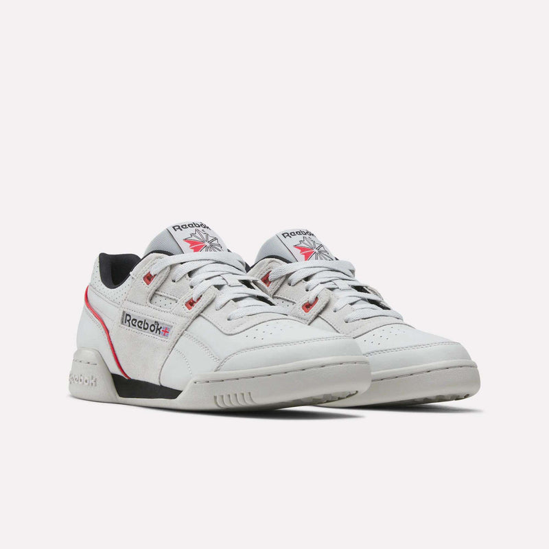 A pair of Reebok Workout Plus Shoes in white with red and black accents, featuring the Reebok logo and classic design elements, displayed on a light background. These retro-inspired sneakers showcase vintage details that celebrate timeless athletic style.