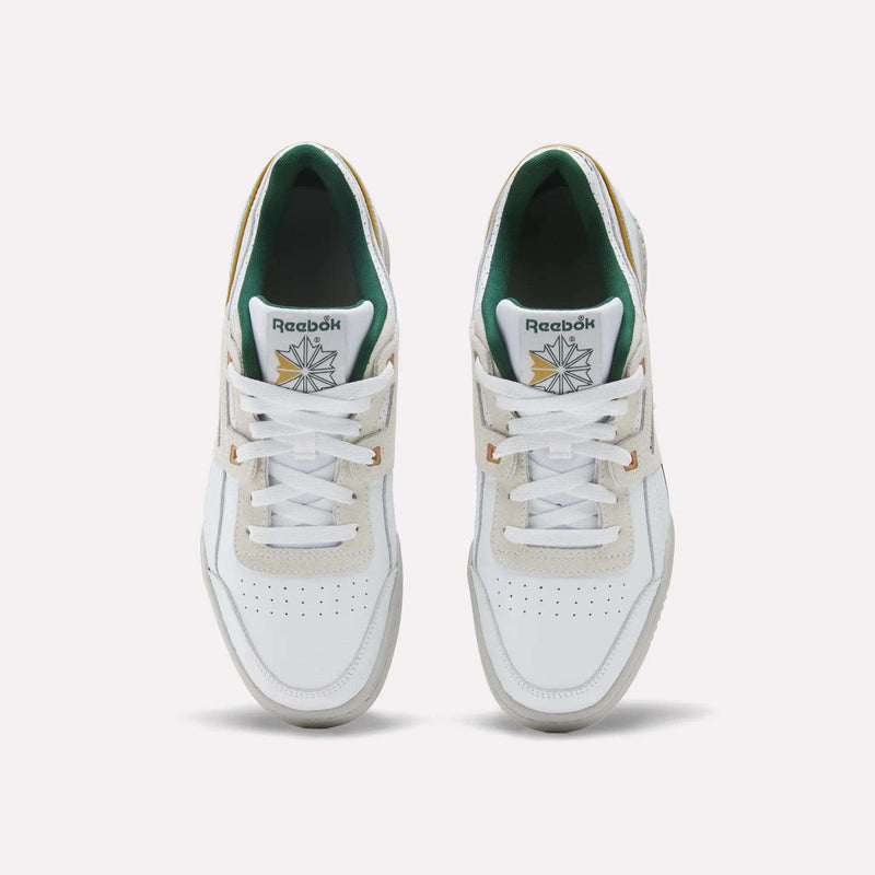 Top-down view of retro-inspired Reebok Workout Plus sneakers in white, featuring green inner lining, tan heel tabs, and white laces.