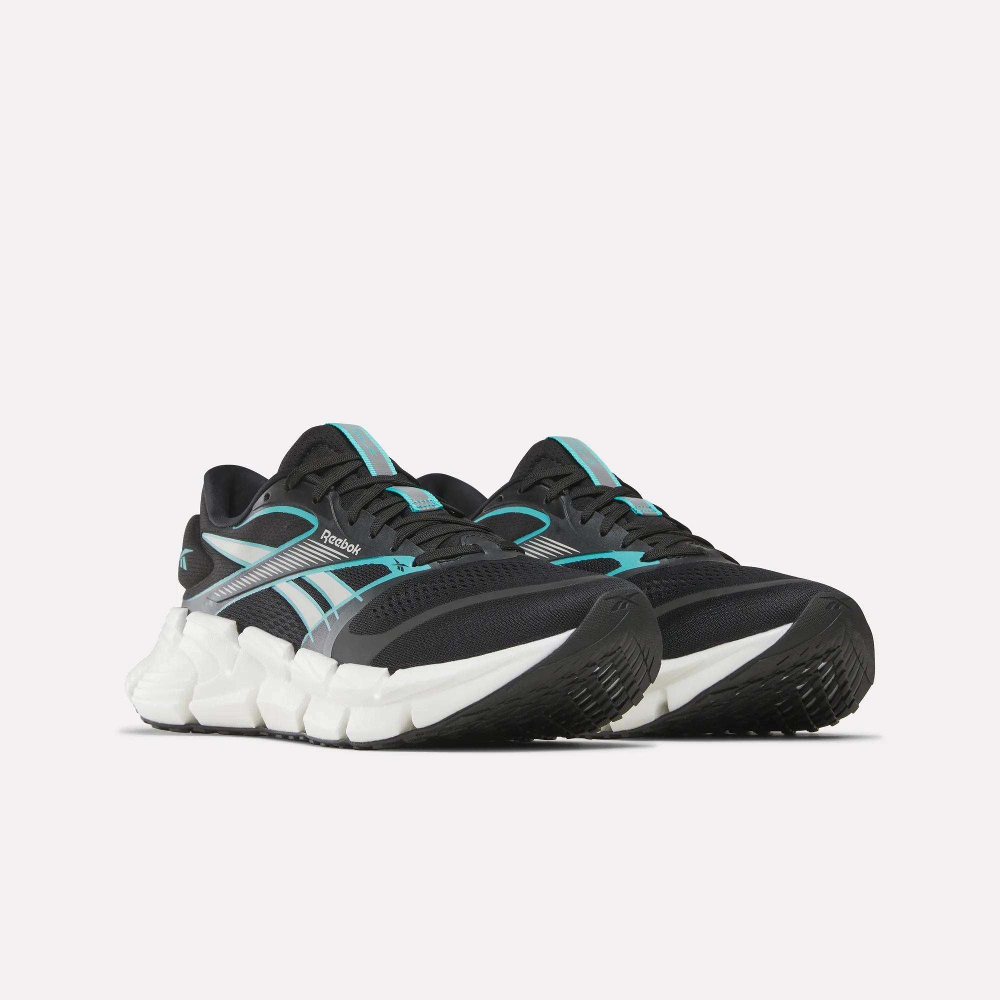 The Reebok Men's FloatZig 2 Running Shoes feature a black upper with teal and white accents, a supportive design, chunky white sole, energy-returning cushioning, and a textured black outsole, shown against a plain white background.