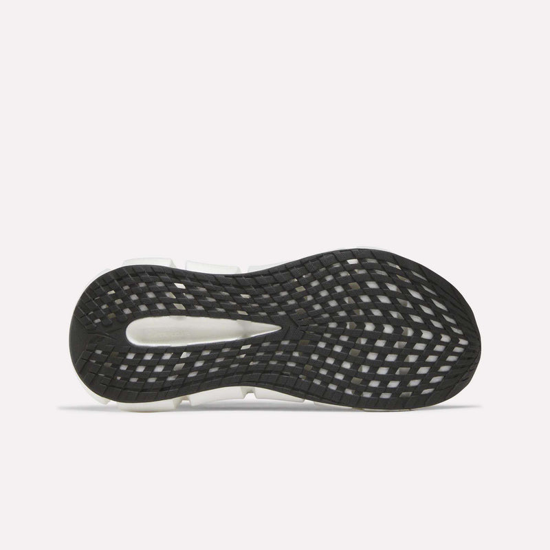 The image displays the black rubber outsole of Reebok Women's FloatZig 2 Running Shoes with a grid tread and white segments for traction and flexibility, set against a plain white background to highlight Superfloat+ cushioning comfort.