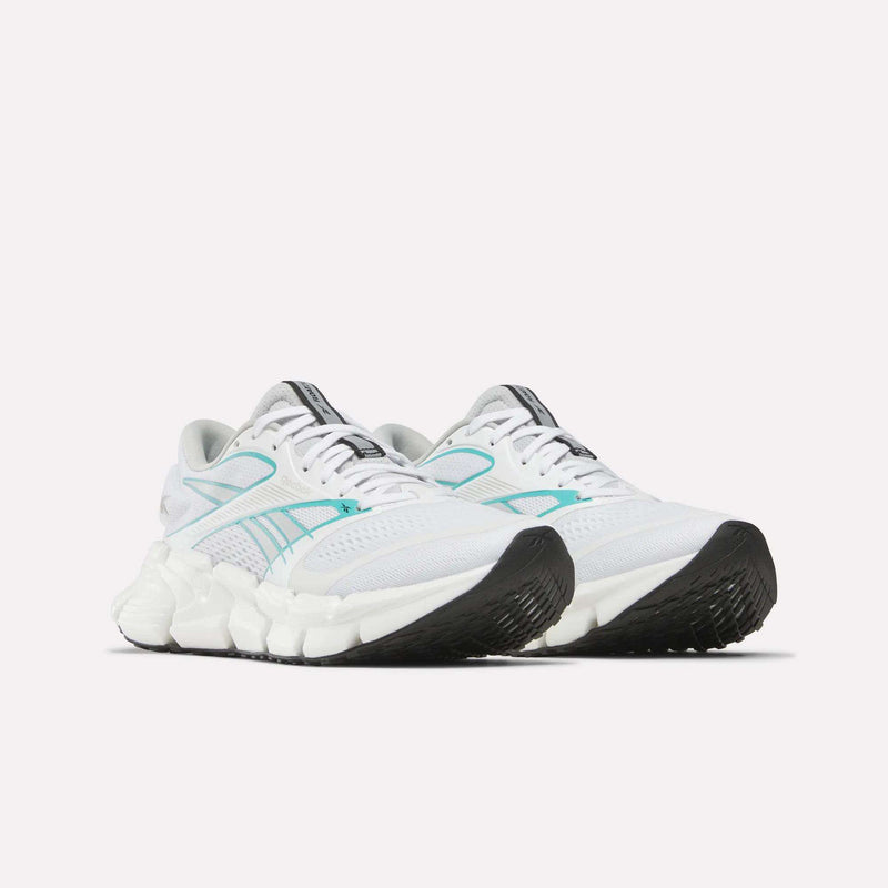 A pair of Reebok Women's FloatZig 2 Running Shoes with white uppers, light blue accents, black soles, and a chunky Superfloat+ midsole are positioned side by side on a plain white background.