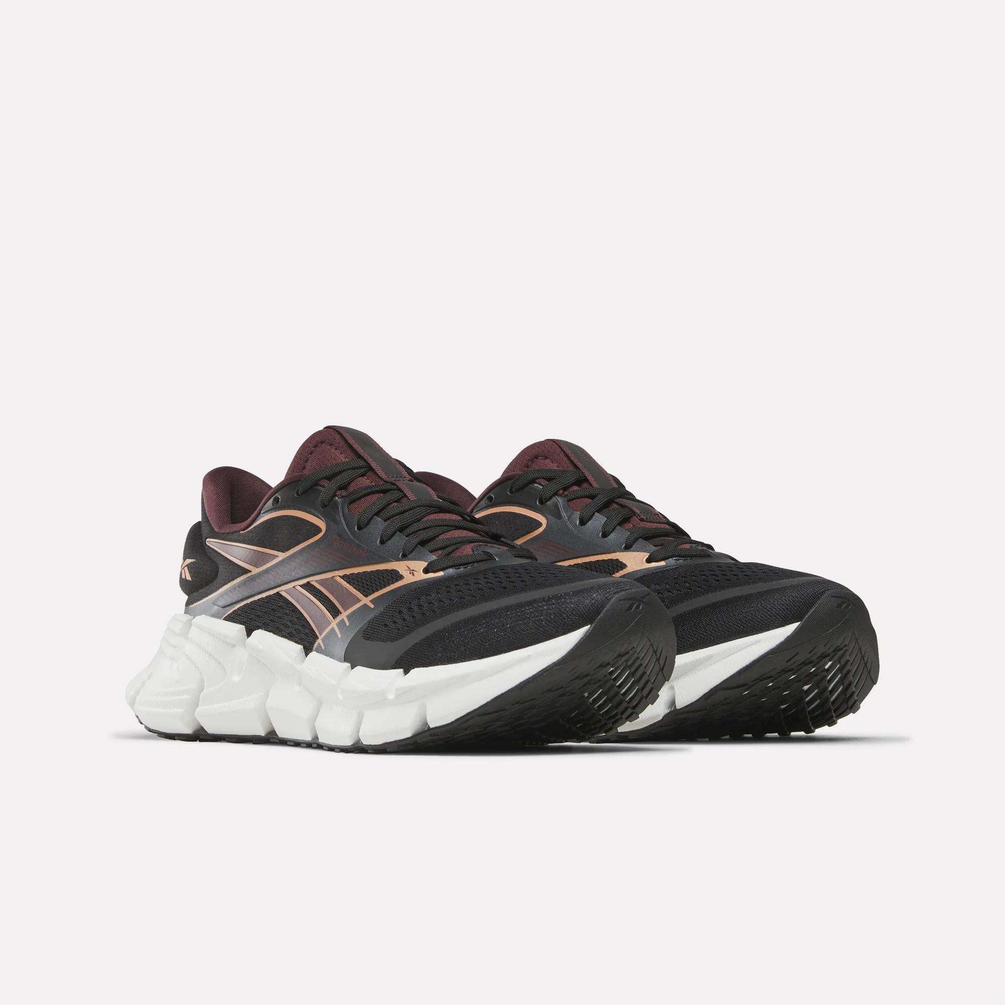 Reebok Women's FloatZig 2 Running Shoes feature maroon accents, a thick white sole, and Superfloat+ cushioning for an ultra-springy ride.