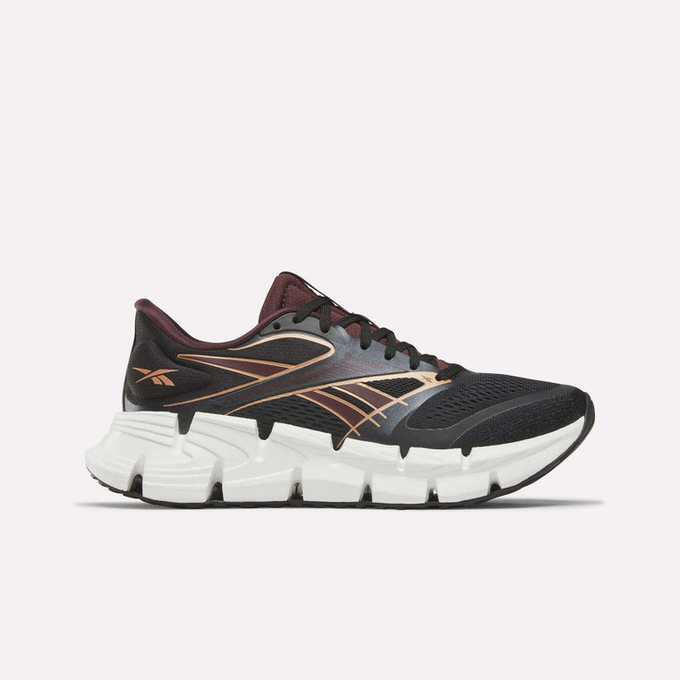 The Reebok Women's FloatZig 2 Running Shoes in Black/Metallic feature a breathable mesh upper and a cushioned Superfloat+ sole for comfort, with maroon and gold accents, shown against a plain white background.