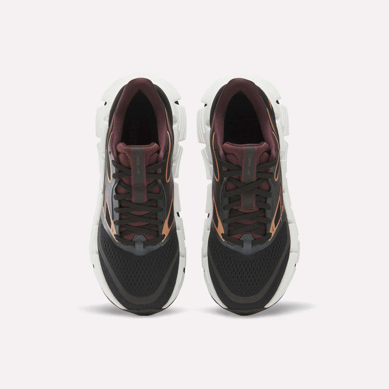 A pair of Reebok Women's FloatZig 2 Running Shoes seen from above, with black mesh toes, dark maroon tongues and collars, brown accents, and thick white Superfloat+ cushioned soles against a light background.