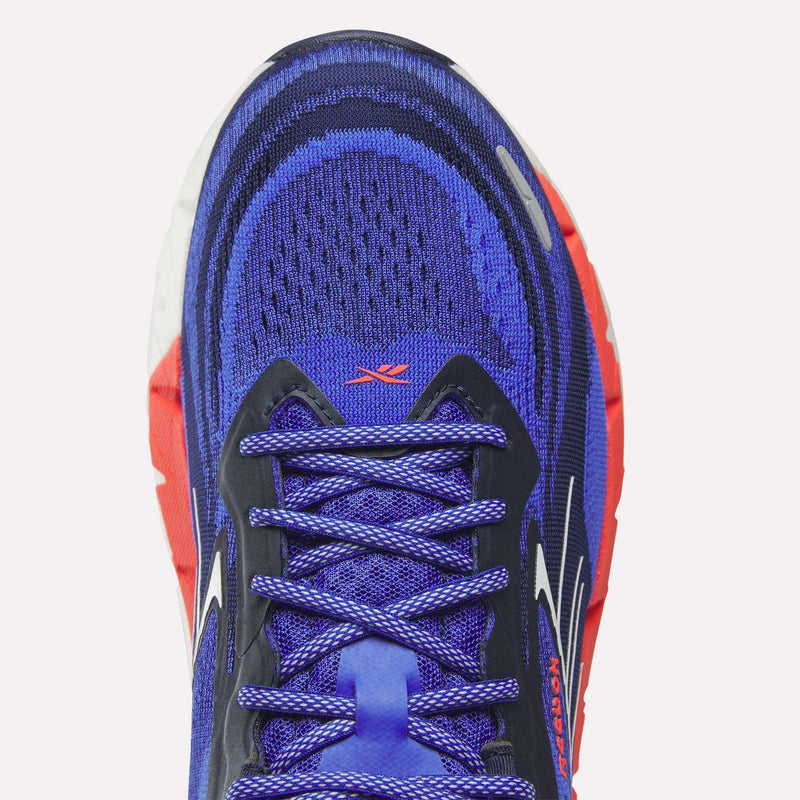 Top view of Reebok Men's FloatZig Double Running Shoes in blue and purple with a mesh toe, patterned laces, black overlays, white logos, and a chunky red/white sole—perfect for max-cushioned miles with StableStack support.