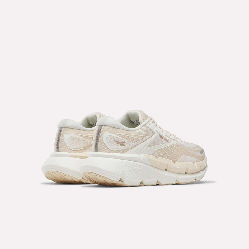 A pair of Women's FloatZig Double Running Shoes by Reebok in chunky off-white with beige accents and thick, textured soles—perfect for max-cushioned miles—viewed from the back left side against a plain light background.