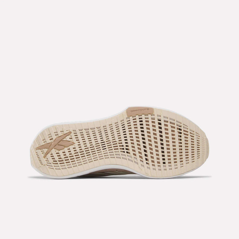 The image displays the beige and cream-colored sole of Reebok Women's FloatZig Tread Running Shoes, with a geometric tread pattern and the Reebok logo on the left side.