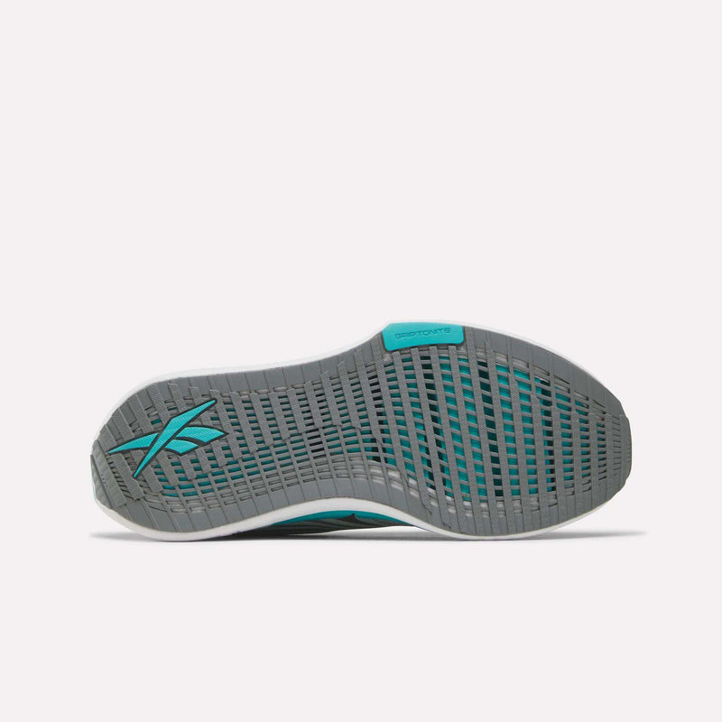 The image displays the gray and teal rubber sole of the Reebok Women’s FloatZig Tread Running Shoes, featuring grid-like tread patterns designed to deliver excellent grip during treadmill workouts. The Reebok logo is visible on both the heel and side.