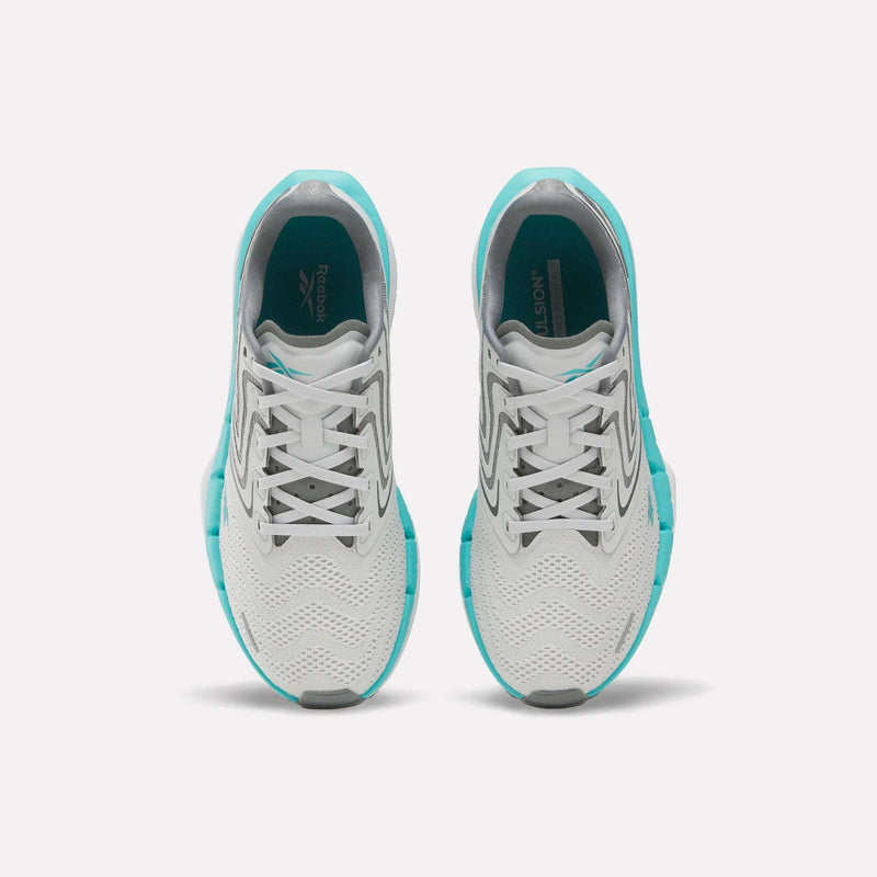 Top view of a pair of Reebok Women’s FloatZig Tread Running Shoes in white with teal accents and gray details, placed side by side on a plain white background—perfect for treadmill workouts.