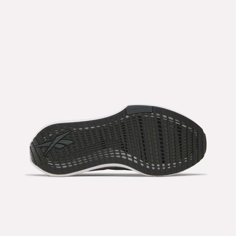 The image displays the black rubber outsole of the Reebok Women’s FloatZig Tread Running Shoes, featuring a textured grip pattern and the Reebok logo on the left side, showcasing design elements tailored for treadmill running.