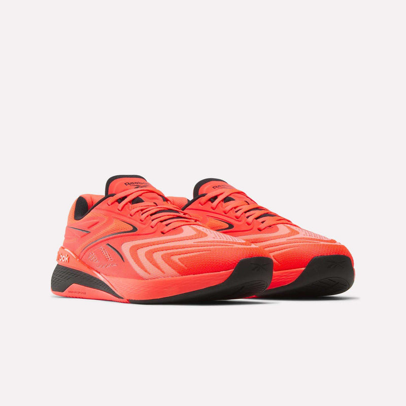 A pair of Reebok Nano X5 Edge Training Shoes in vivid red, accented with black soles and distinctive wavy line patterns, display the signature Reebok logo on the side. Set against a plain white background, these shoes highlight their performance-driven design.