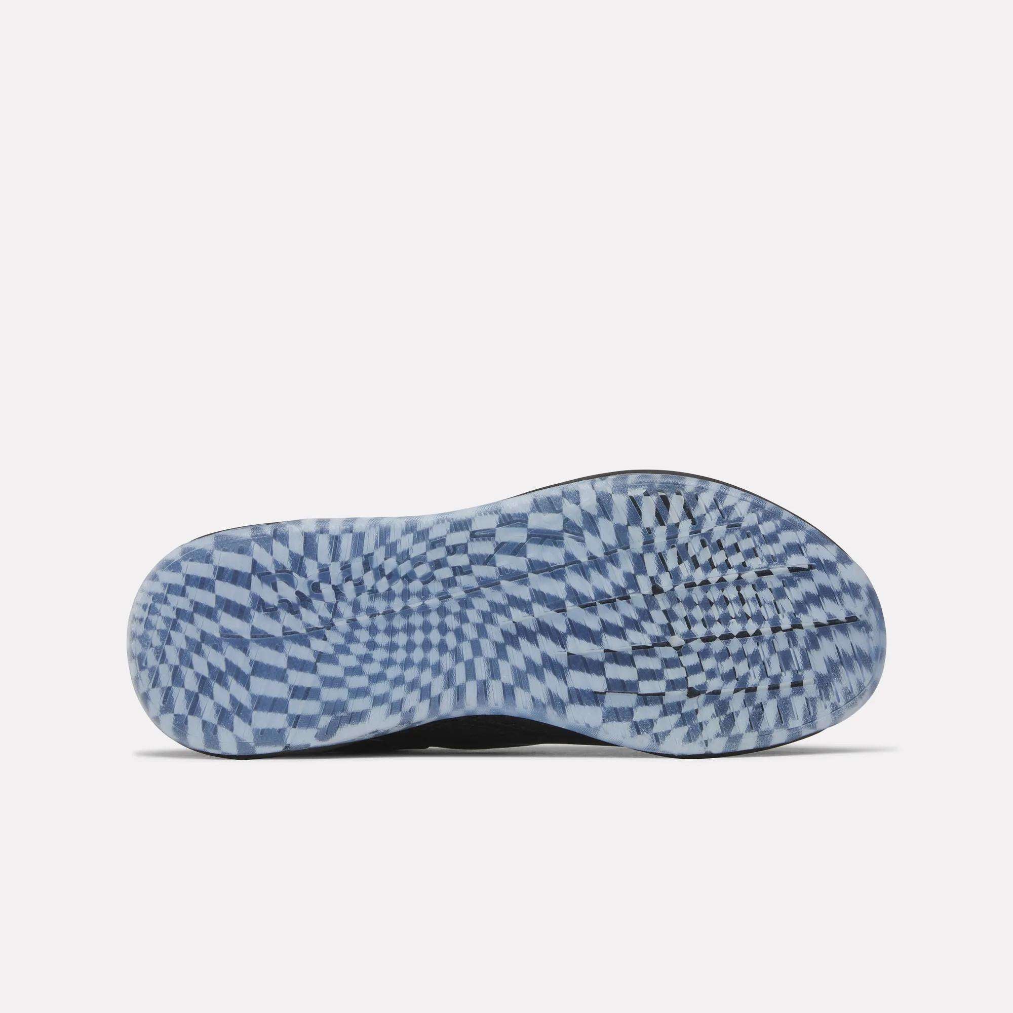 The image shows the sole of a Women's Nano X5 Edge Training Shoe by Reebok with a blue and white checkerboard pattern creating a swirling optical effect against a plain, light background.