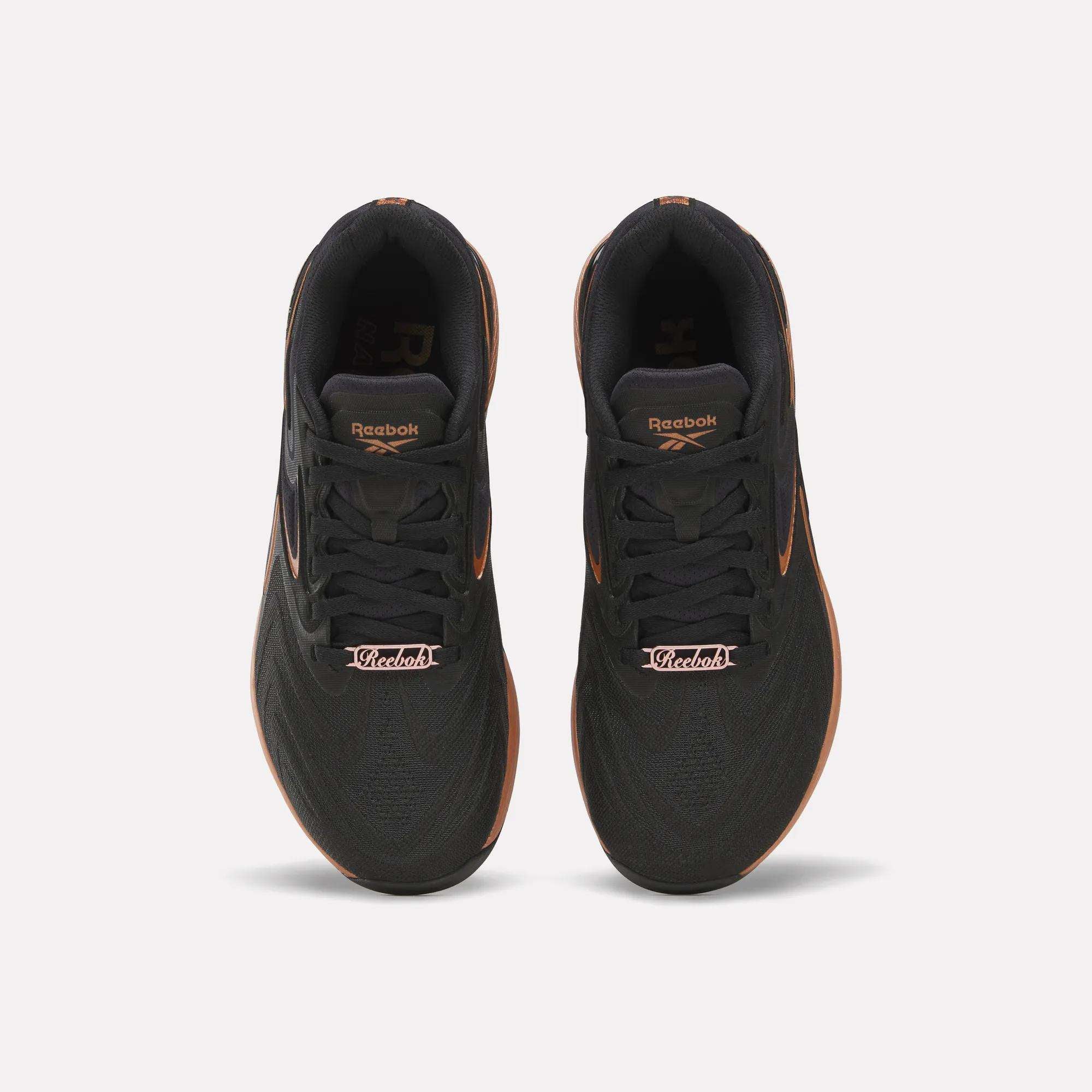 Top view of Reebok Women's Nano X5 Edge Training Shoes in black with orange accents and “Victoria” on the laces—ideal for your next HIIT class.