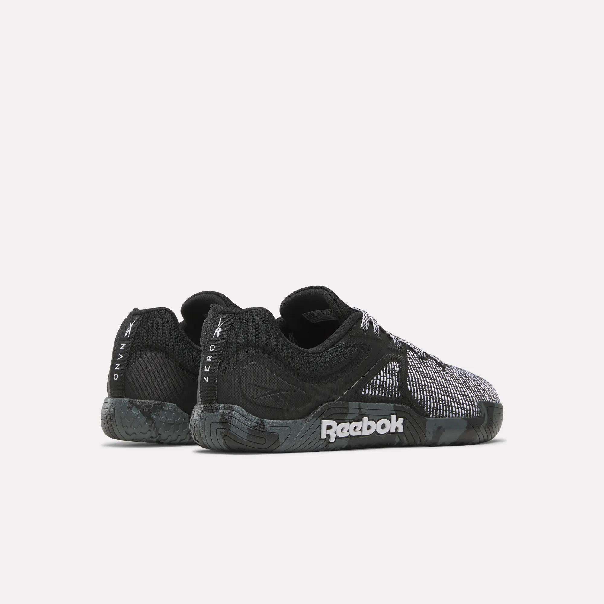 A pair of black and gray Reebok Nano Zero Training Shoes with textured soles and mesh details, ideal for strength training. Viewed from the side and slightly angled to the back. The Reebok logo is visible on the sole and heel.