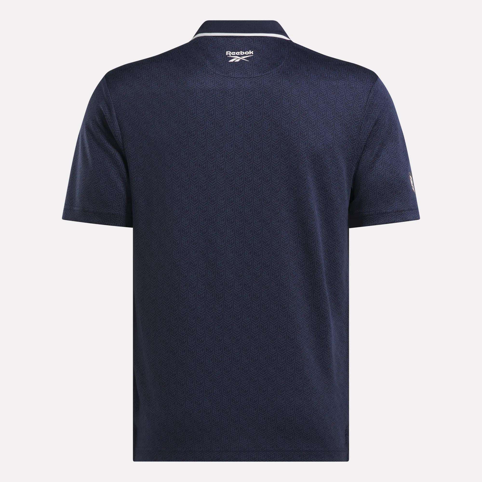 Back view of the Men's BDC Signature Polo Shirt by Reebok in navy blue, featuring RBK-DRY fabric, a subtle textured pattern, a collar, and the Reebok logo below the neckline.