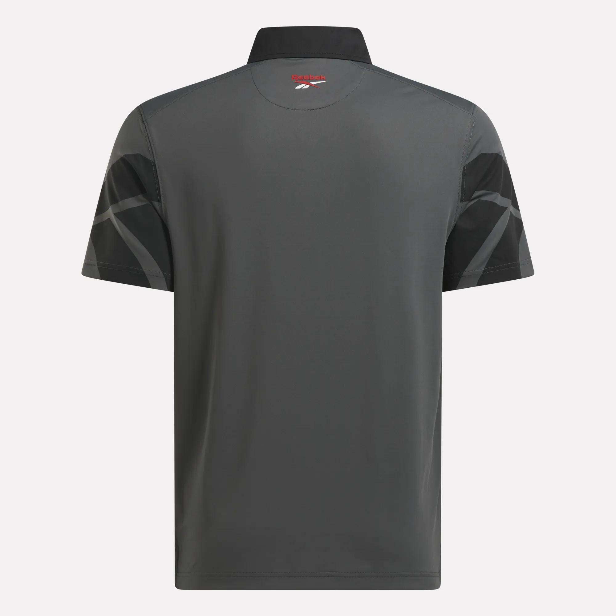 Back view of the Reebok Men's Signature Vector Colorblocked Polo Shirt, showing short sleeves, black geometric patterns, a small red and white logo below the collar, and RBK-DRY fabric for comfort on or off the course.