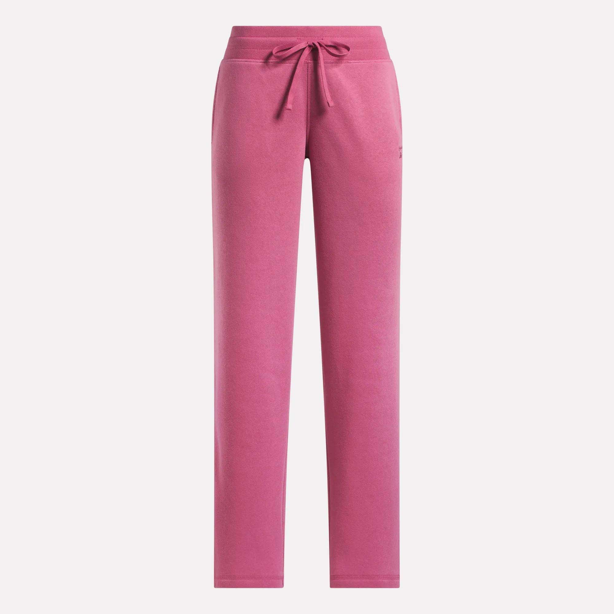 Women's Cozy Classic Sweatpants by Reebok in pink, featuring a drawstring waistband, straight-leg fit, subtle side pockets, and made from a soft cotton blend. Shown on a plain white background.
