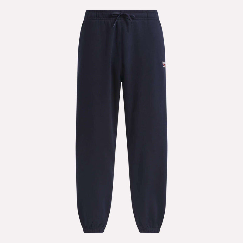 Introducing the Reebok Men’s Logo Relaxed Fleece Pants in navy blue, featuring an elastic waistband with drawstring and elastic cuffs. These pants are finished with a small embroidered Reebok logo on the left upper thigh for signature style, and are designed in a relaxed fit to provide ultimate comfort.