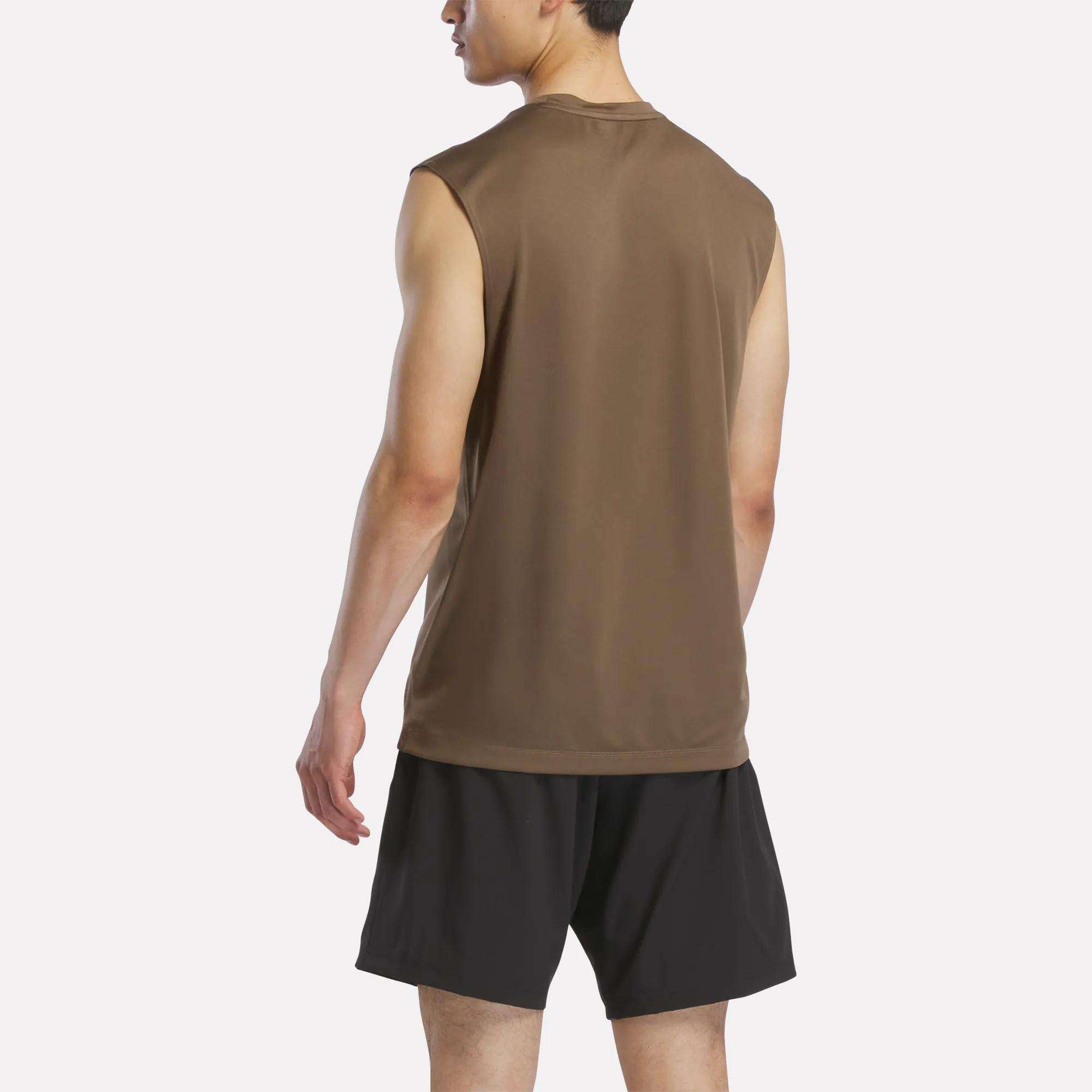 A man faces away, wearing the Reebok Men's Sleeveless Tech Training T-Shirt in brown and black athletic shorts made from lightweight polyester jersey, set against a plain, light background.