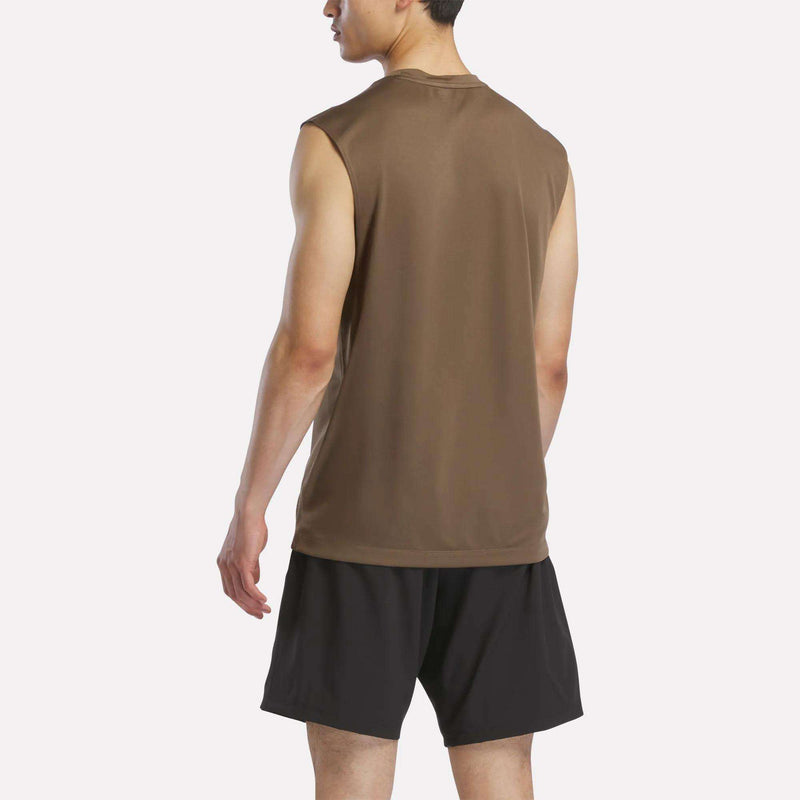A man faces away, wearing the Reebok Men's Sleeveless Tech Training T-Shirt in brown and black athletic shorts made from lightweight polyester jersey, set against a plain, light background.