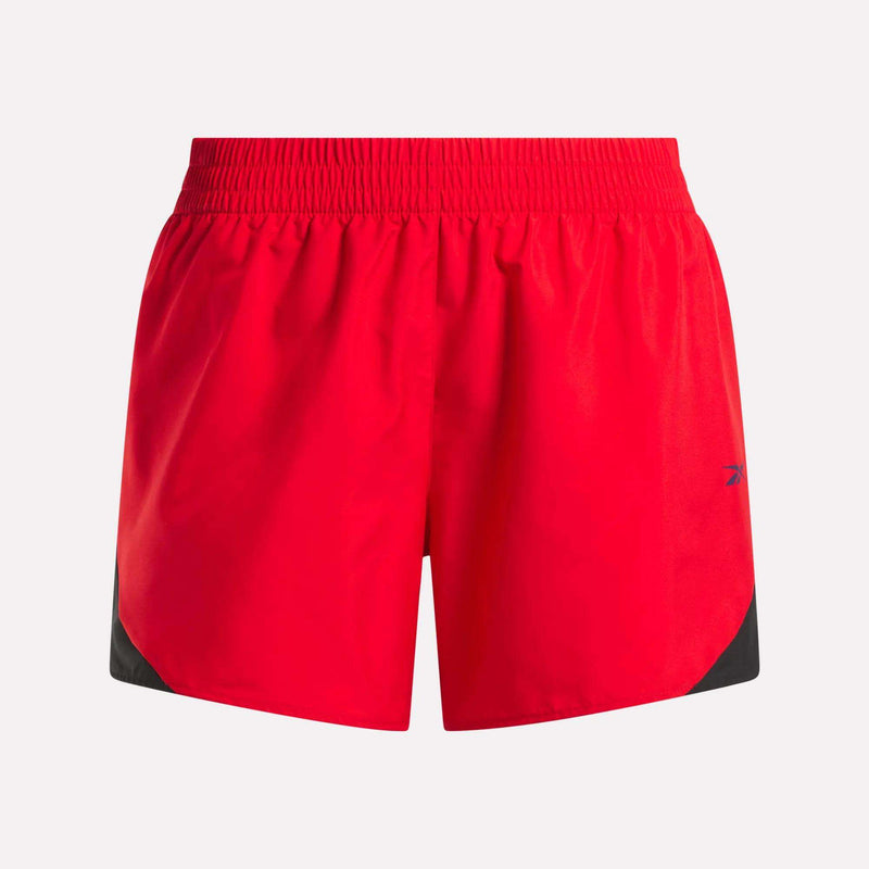 The Women's Colorblocked Woven Shorts by Reebok feature a bright red design with black lower side accents, an elastic waistband, and a small blue logo on the left leg, shown against a plain light background.