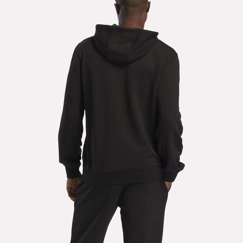 A person is shown from the back, standing against a plain, light background, wearing the Reebok Men's French Terry Hoodie and black pants.