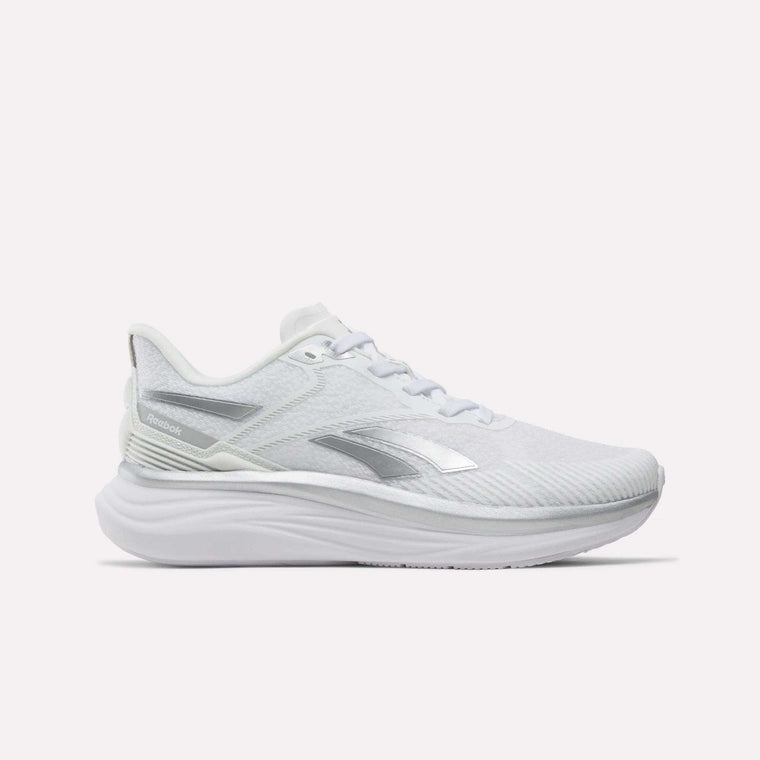Side view of the Reebok Women’s Viva Speed Shoes in white with silver accents, featuring a mesh upper, white laces, and a thick, extra-cushioned sole against a plain light background.