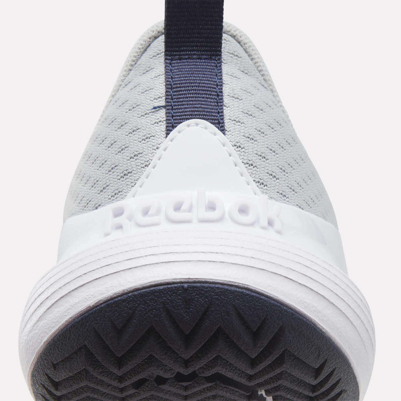 Close-up of the heel of a light gray Men’s Phase Advantage Tennis Shoes Reebok, showing a white midsole with embossed branding and a dark blue patterned rubber outsole.