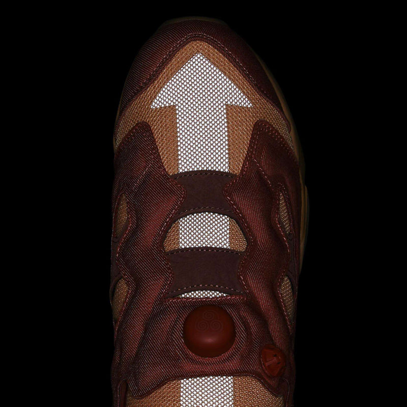 Top-down view of a brown Reebok x Avatar Instapump Fury 94 Shoes sneaker with a reflective white upward-pointing arrow on the toe and a circular inflation pump on the tongue.