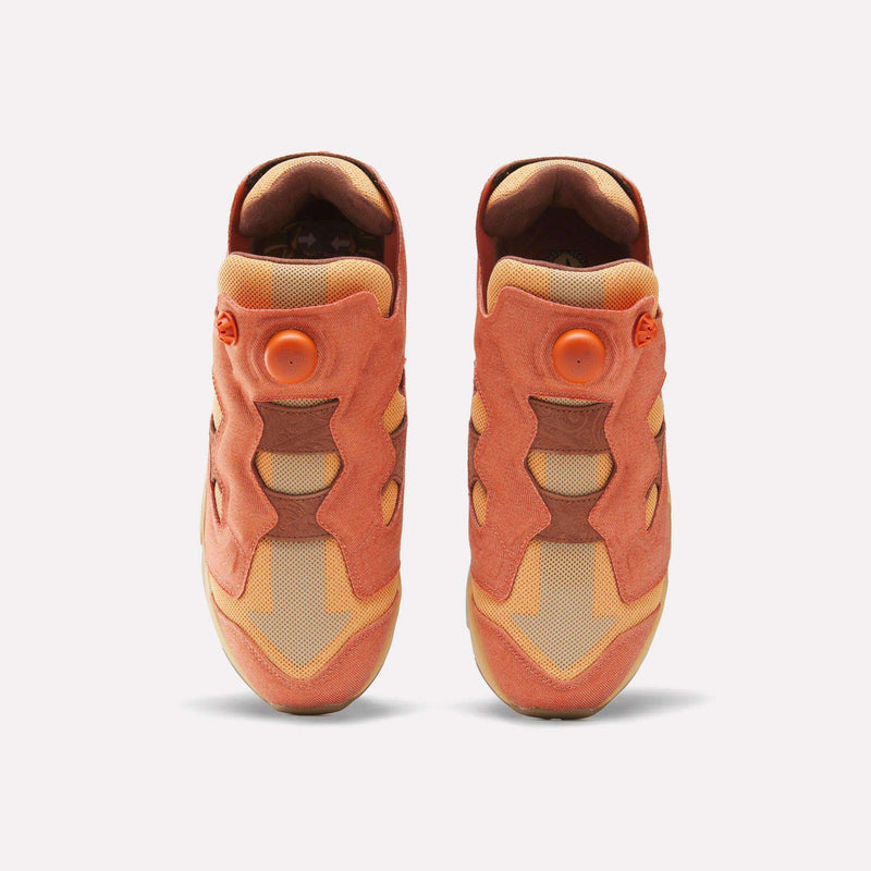 A pair of orange and tan Reebok x Avatar Instapump Fury 94 Shoes featuring a circular air pump button on the tongue.