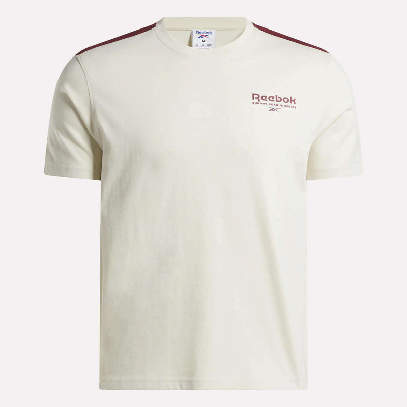 The Men’s Heritage T-Shirt by Reebok features an off-white design with short sleeves, maroon shoulder stripes, and a subtle maroon Reebok logo on the left chest. Made from soft cotton jersey for exceptional comfort, this shirt is displayed against a plain background.