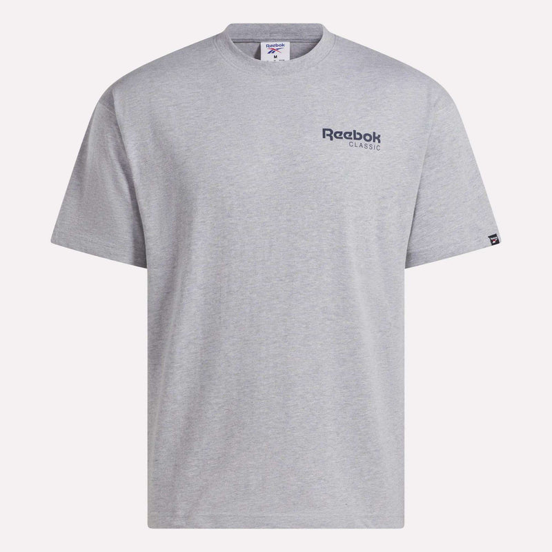 Introducing the Men’s Relaxed Logo T-Shirt by Reebok. This men’s t-shirt features a light gray color, short sleeves, and a classic crew neckline. Crafted from soft cotton fabric for everyday comfort, it displays a small navy Reebok Classic logo on the left chest. The relaxed fit makes it perfect for casual wear, and the shirt is shown laid flat against a white background.